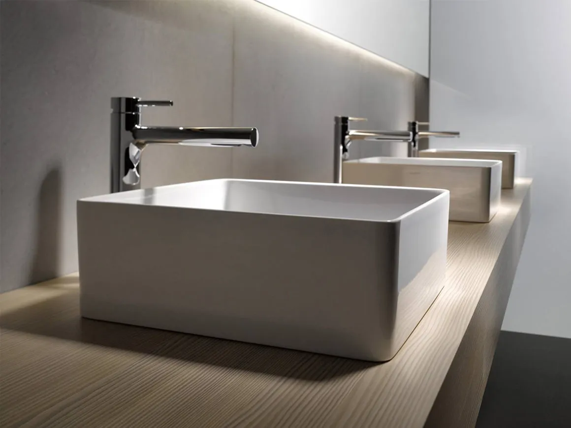 Row of modern rectangular vessel sinks with wall-mounted faucets